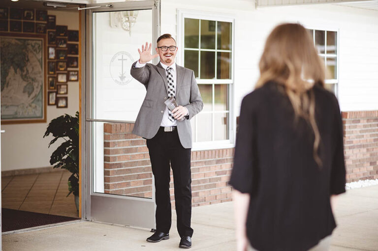 Fractional services a man in suit outside a church welcoming a women