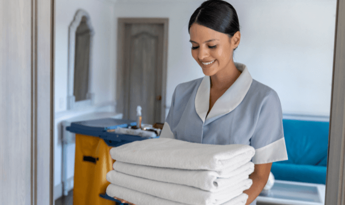 Hospitality Consulting Hotel housekeeper girl have white colour fabric in her hands